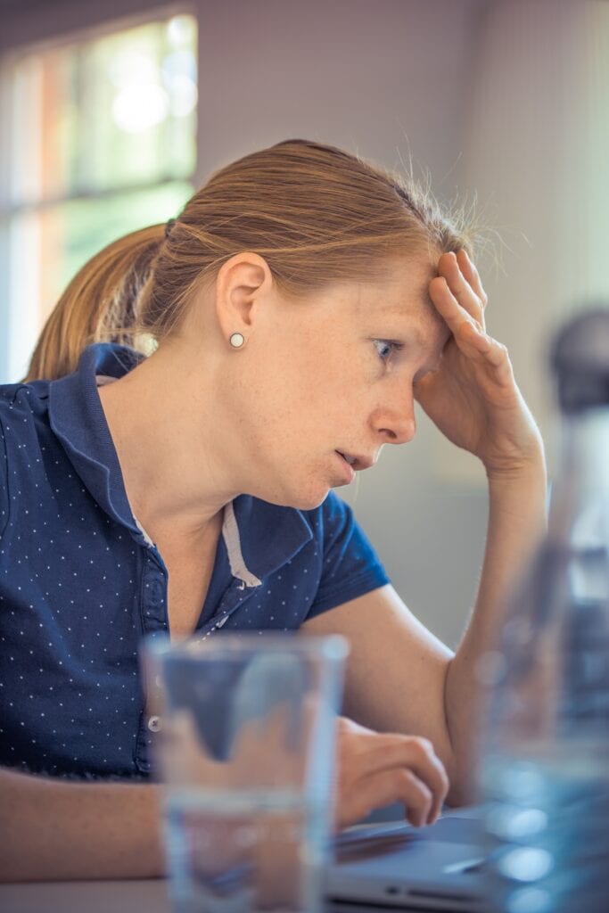 confused woman working at laptop