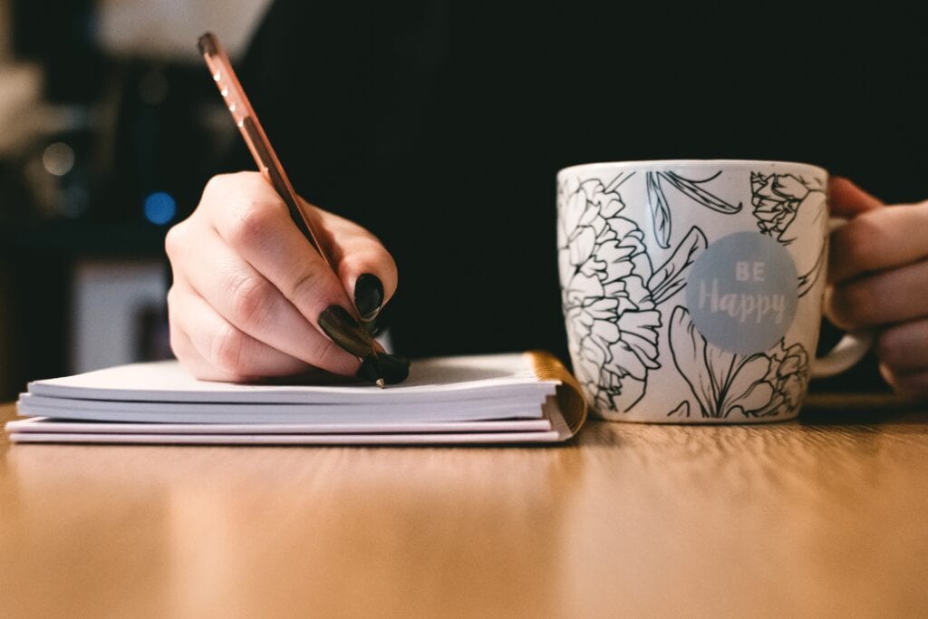 Hand holding pen, writing.