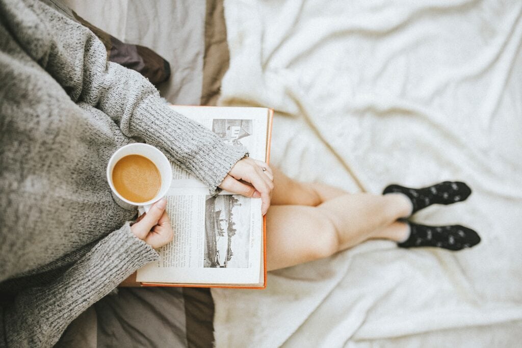 Woman holding book and coffee