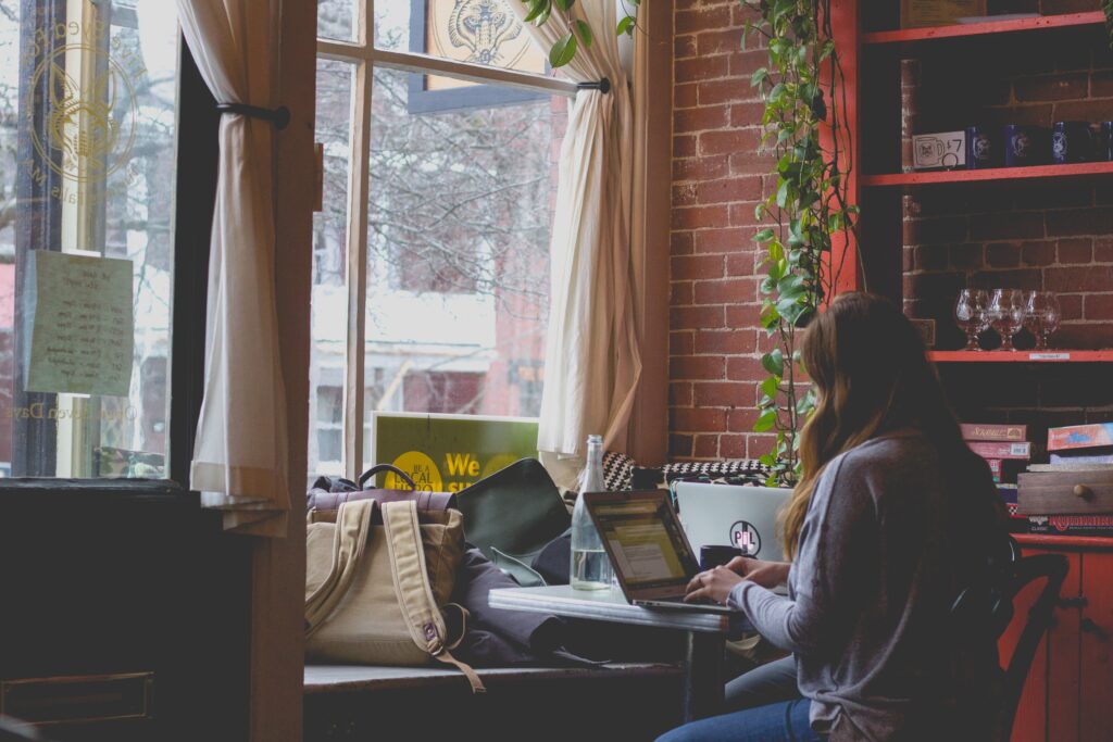 Girl working at laptop in coffee shop