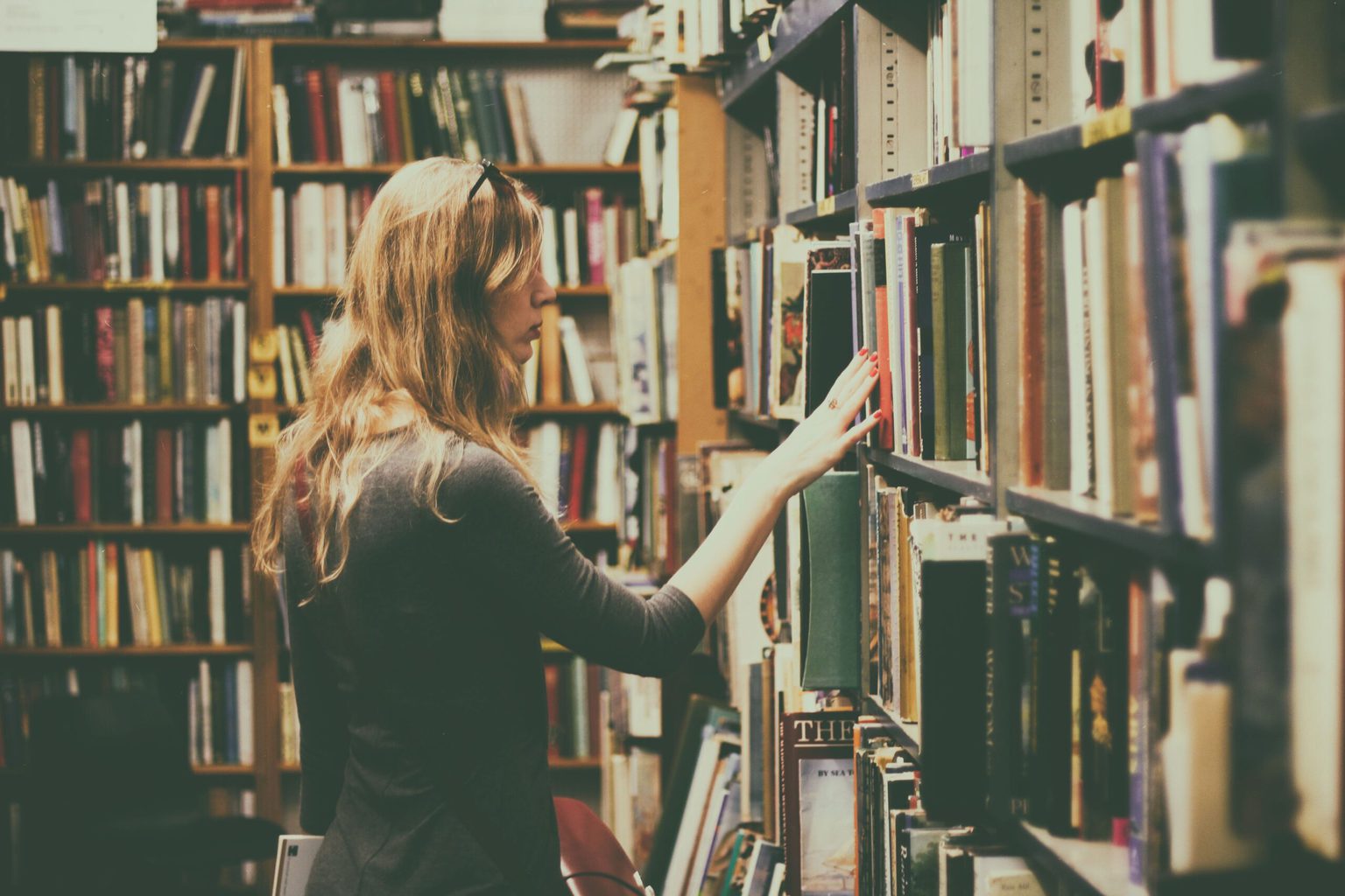 Stock photo of a girl looking through books