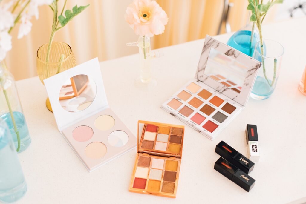 Decluttering tips - get rid of old makeup. Photo of makeup palettes on white table