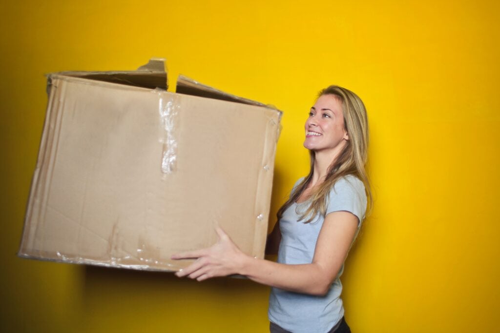 Decluttering tips - four box method woman holding box