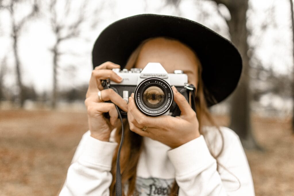 girl holding camera over face