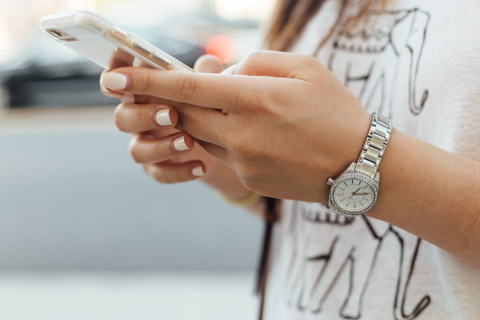 Sleeping tips image: woman texting with watch on and white fingernails