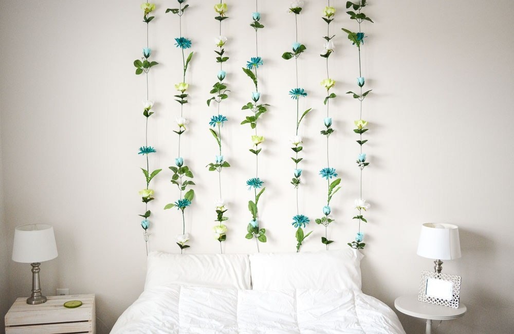 white bed with hanging flower headboard