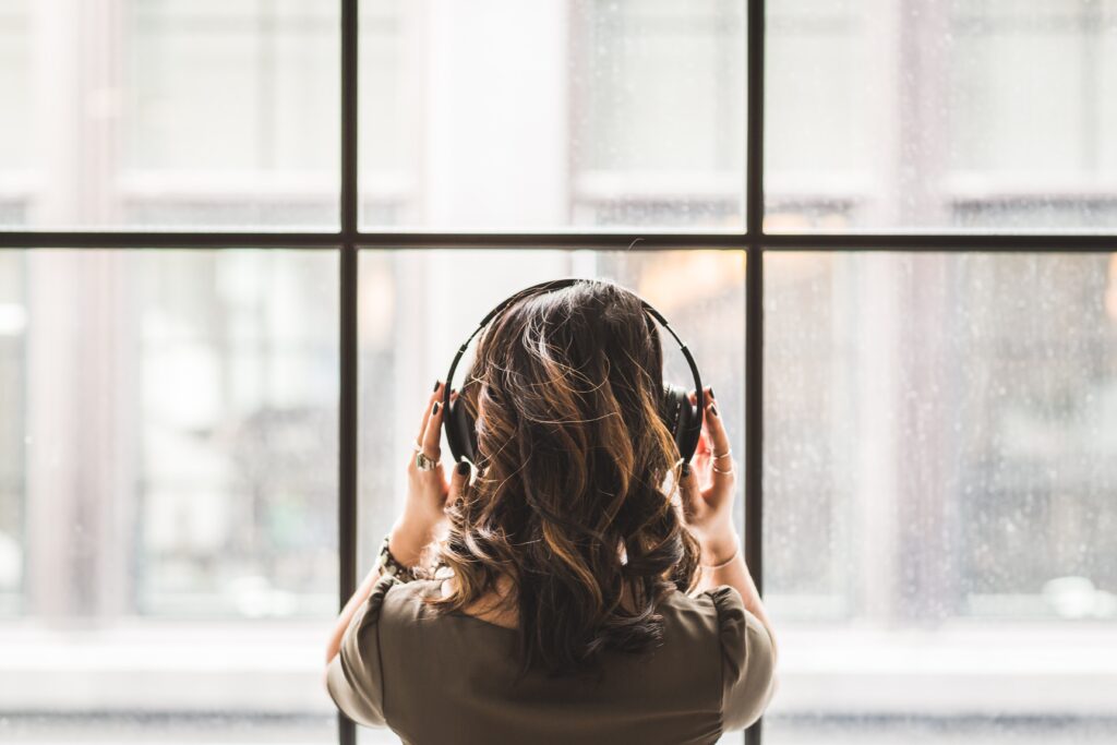 Woman listening to music through headphones.