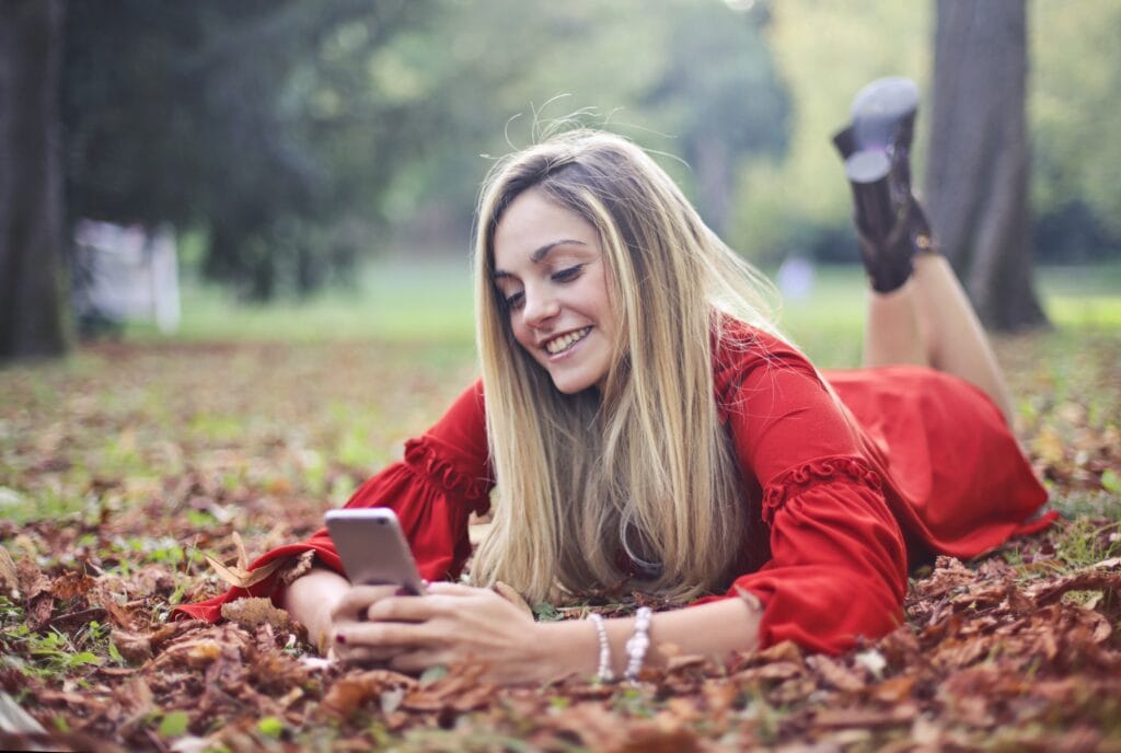 Woman smiling and texting on phone.