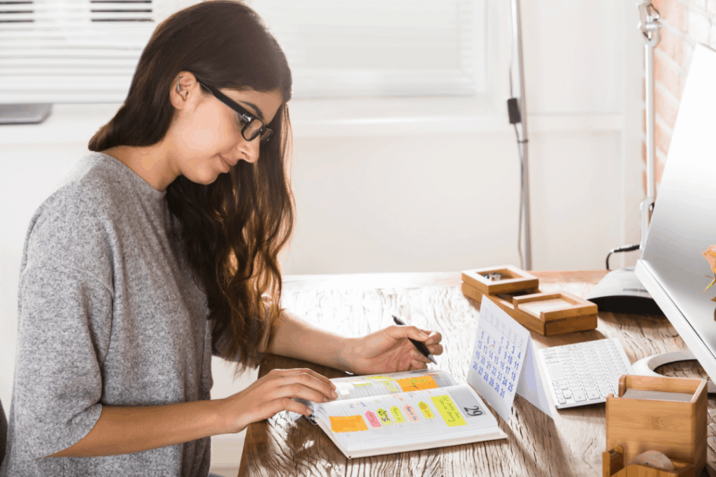 Woman writing out a schedule for her online classes