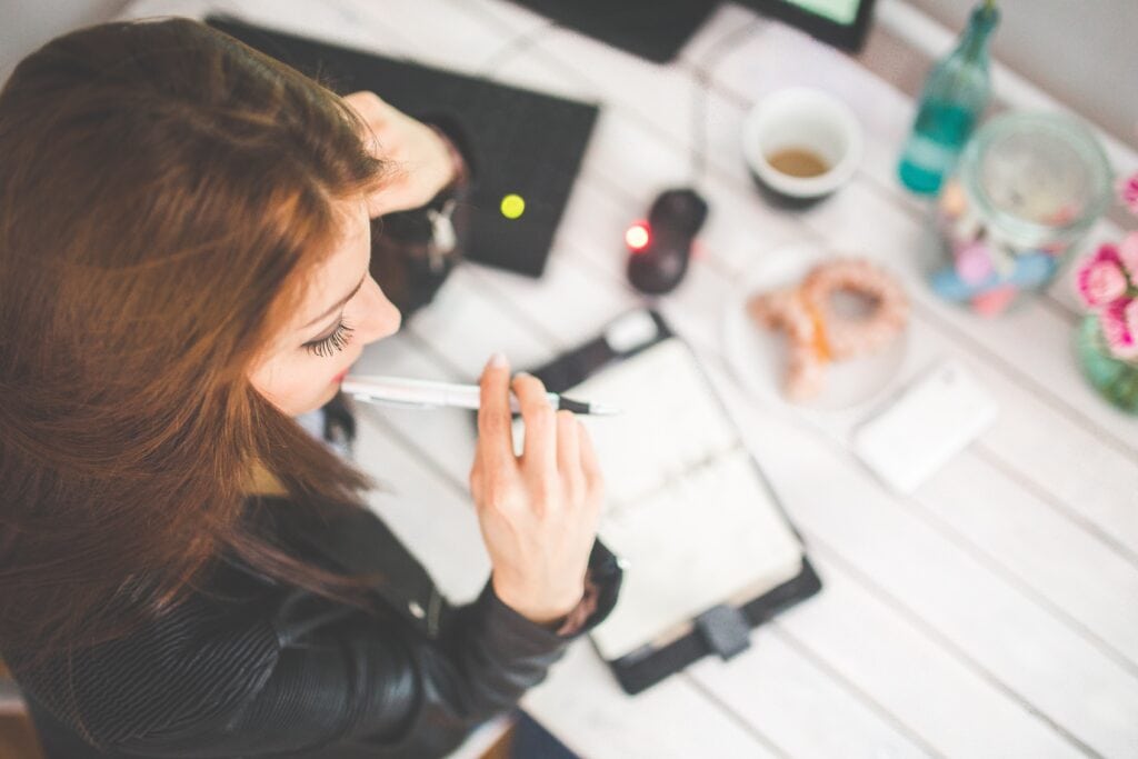 Woman holding pen, studying.