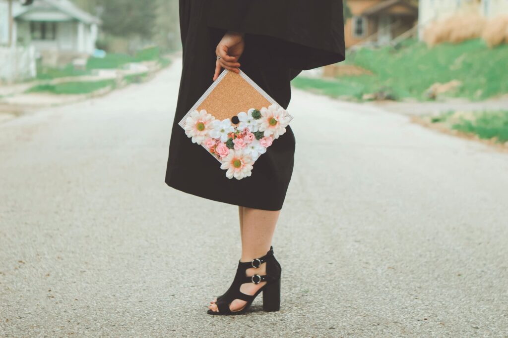 woman holding decorated graduation cap in road
