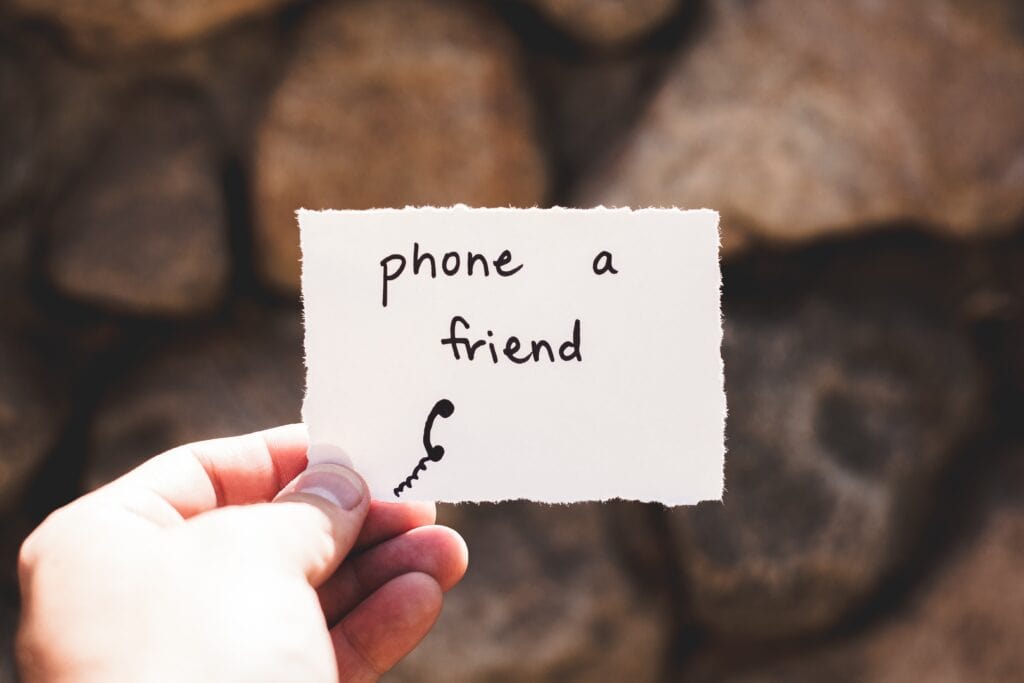 person holding note that reads phone a friend.