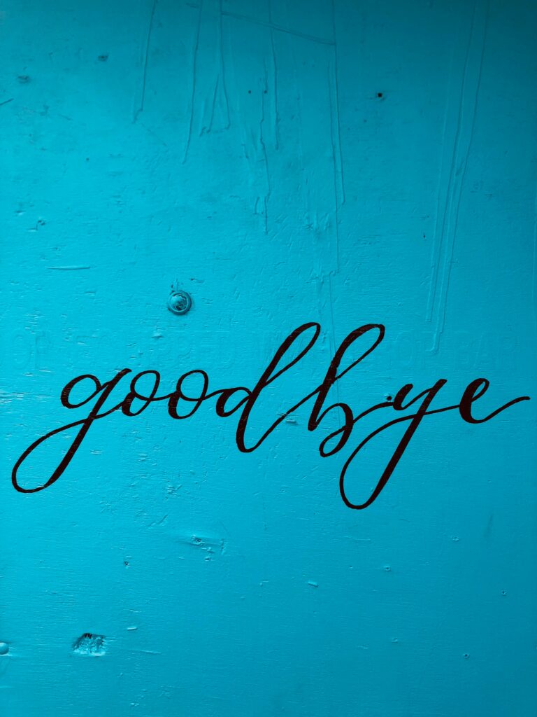 cursive goodbye painted on blue background