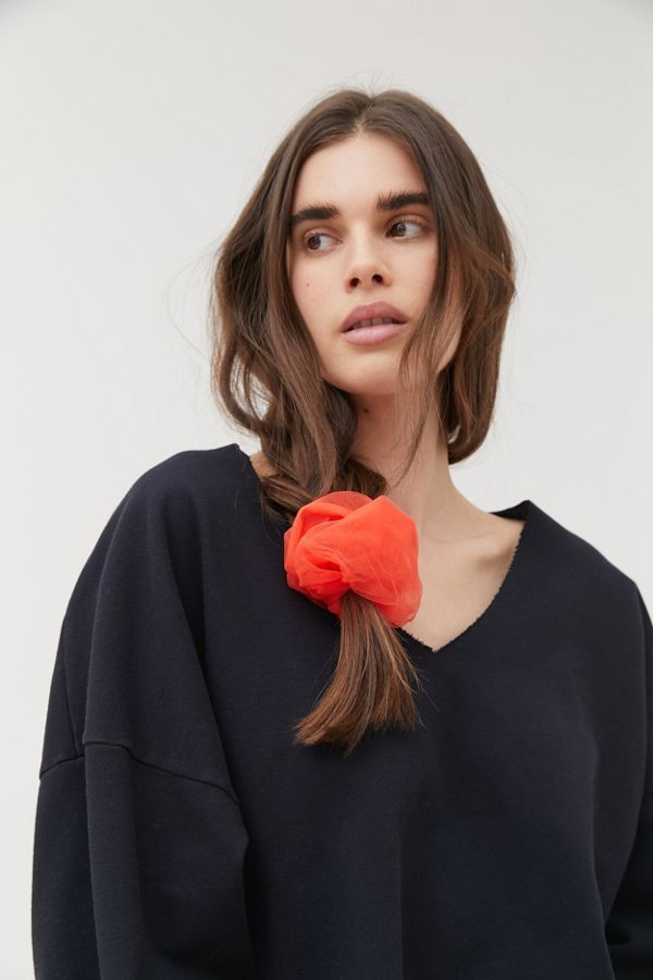 Girl in black shirt and coral orange scrunchie.