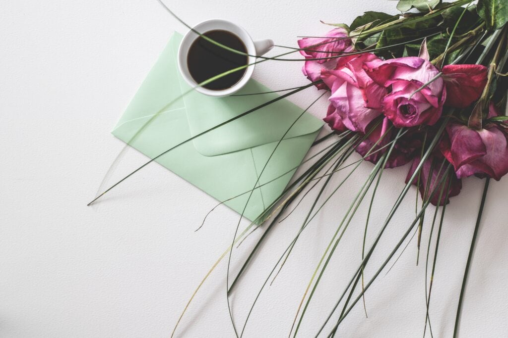 Coffee, flowers, and envelope.