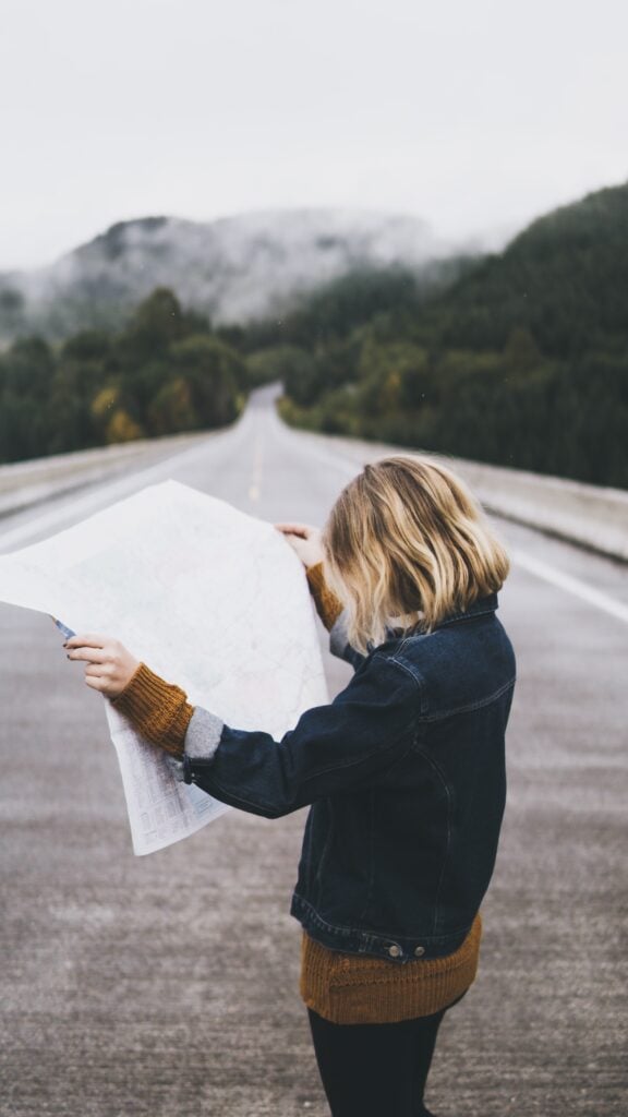 Woman looking at map on road