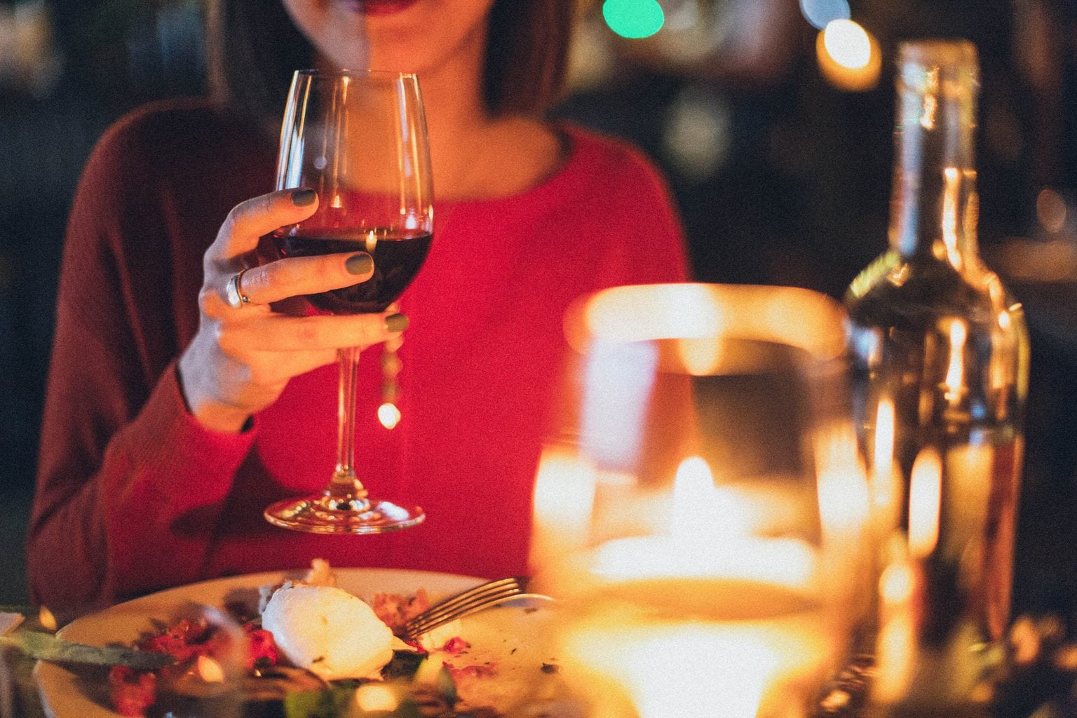 at home date ideaswoman holding glass of wine over dinner tablesource: elinasazonova from Pexels