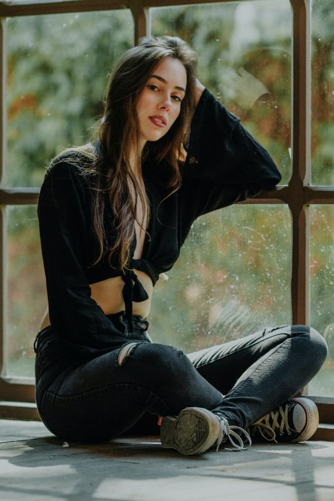 girl posing by mirror wearing all black