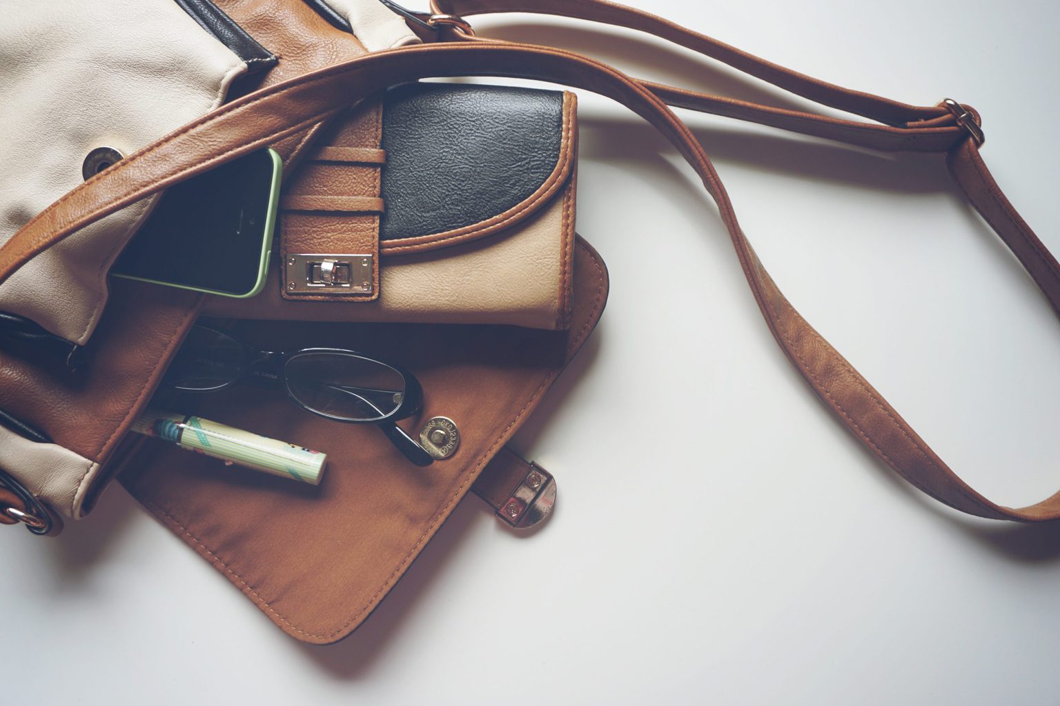 purse with wallet pen and glasses scattered out of it, how to find your style