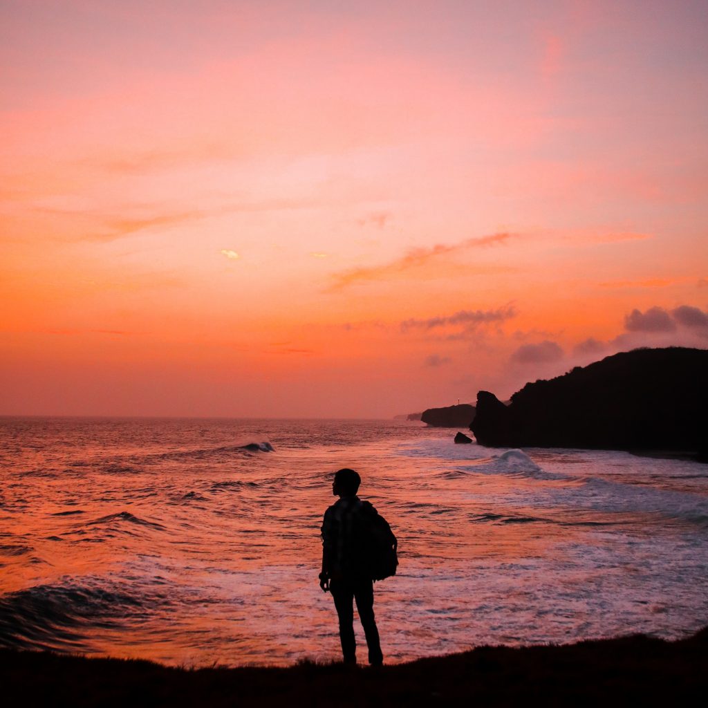 Stock photo of a man standing in front of a sunrise