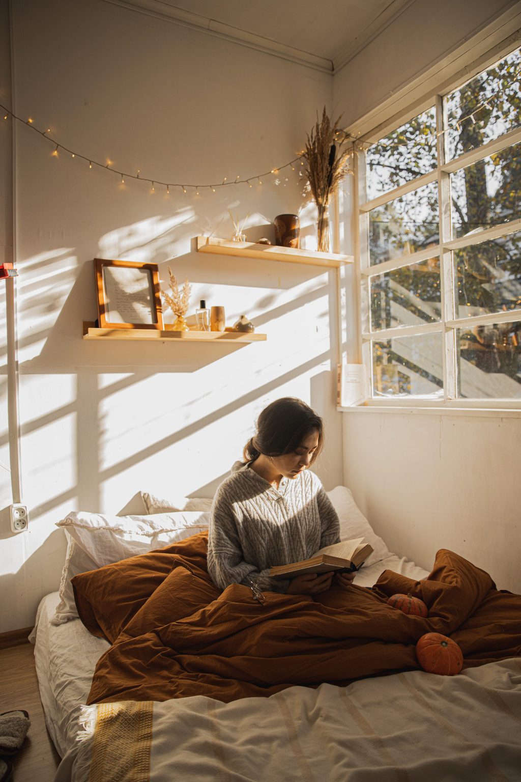 girl reading with book on bed