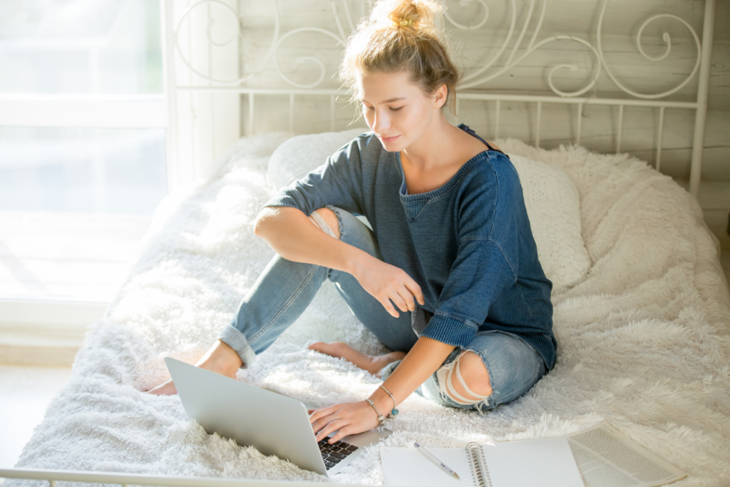 Woman in bed with laptop studying