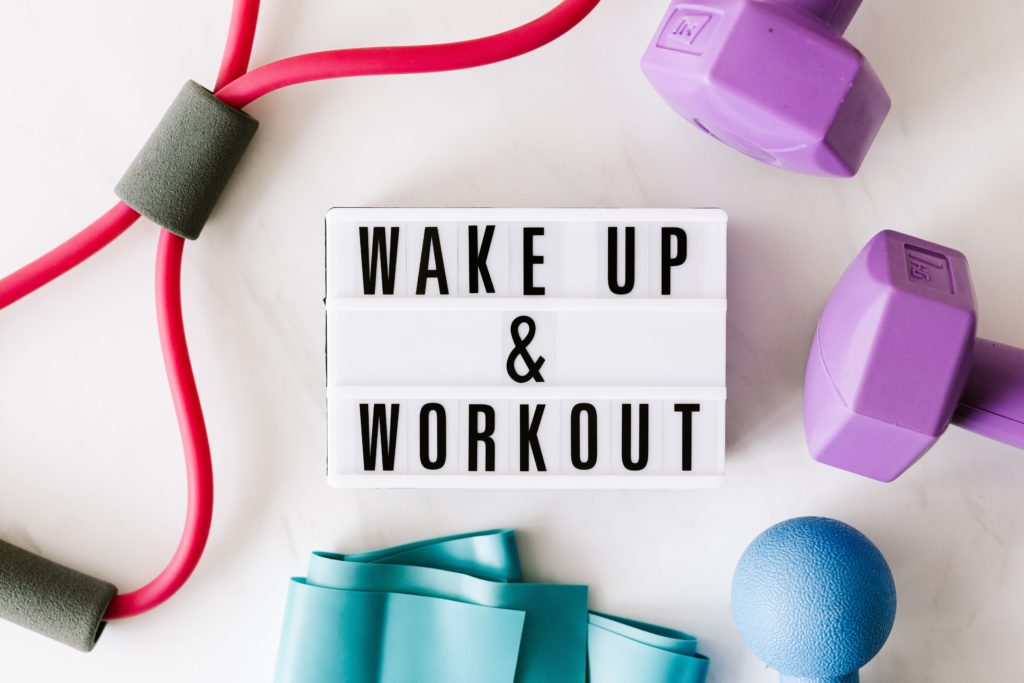 Workout gear surrounding a sign that says "wake up & workout"Pexels image by Karolina Grabowska