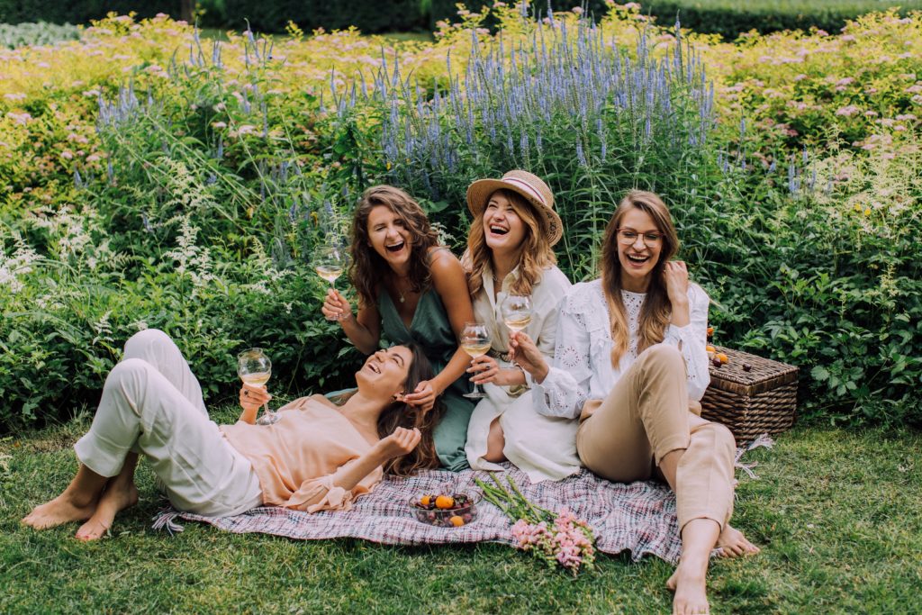 Friendship changes in college - Four girls having a picnic outside.