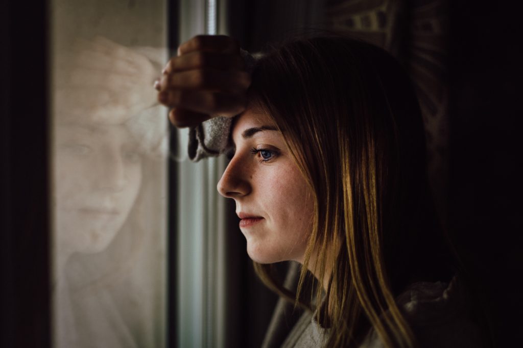 A girl leaning against a window.