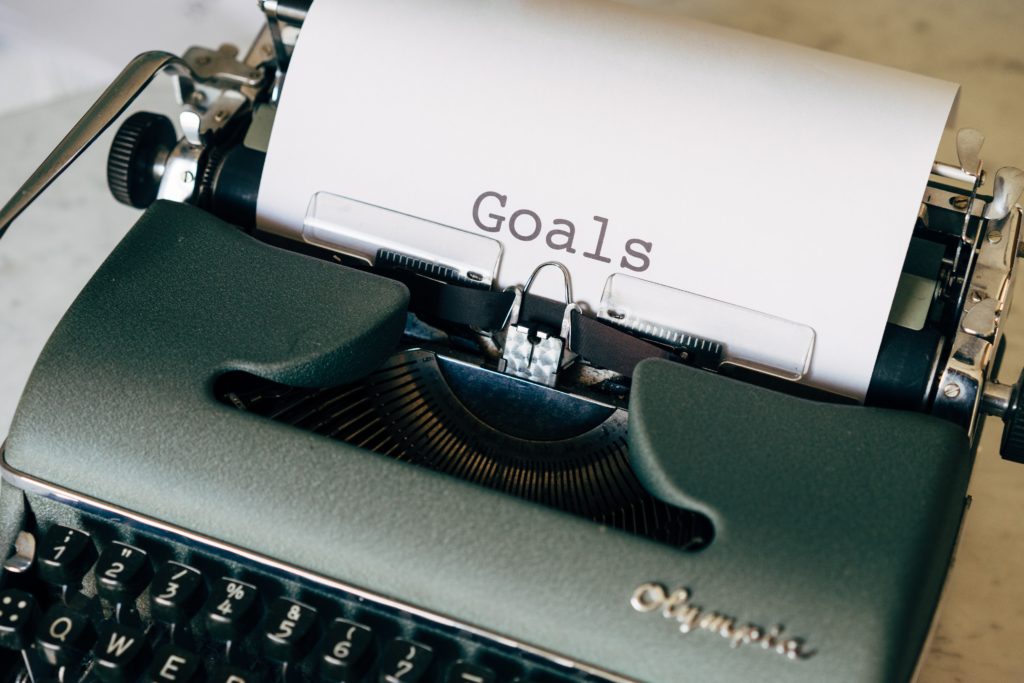 A type writer and paper with the word "Goals" on it. 