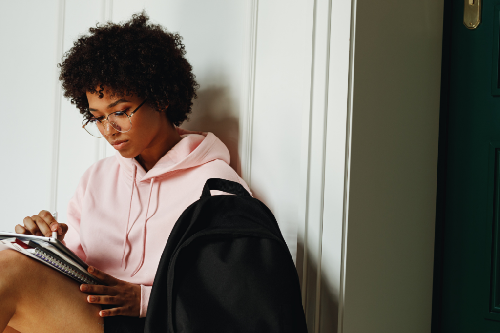 Woman wearing a pink sweatshirt studying for an exam