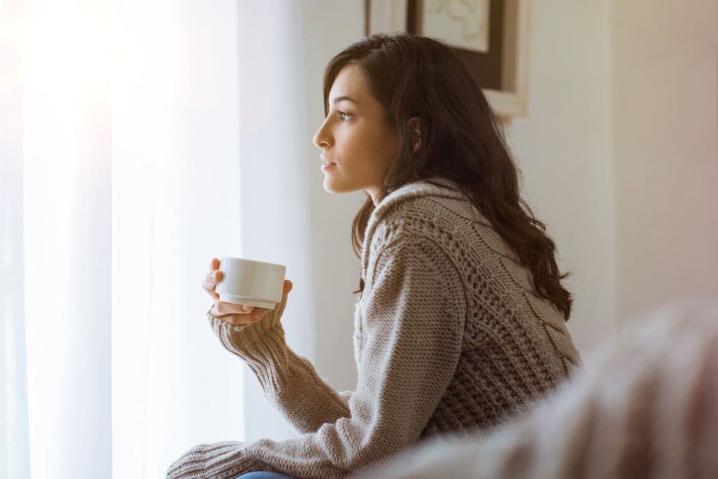 Woman thinking with coffee in hand