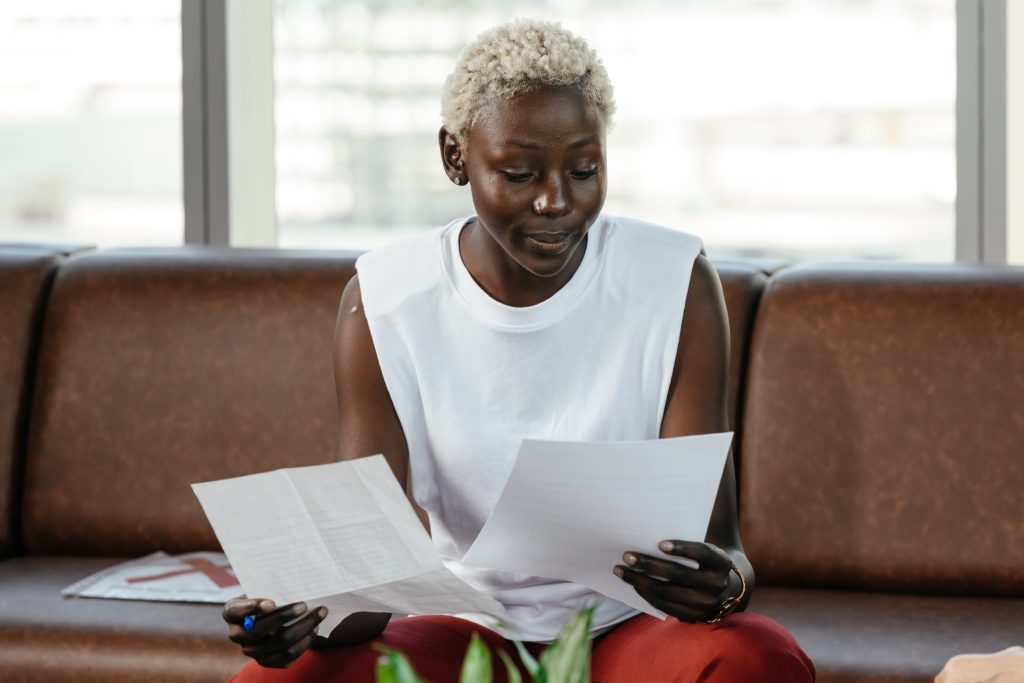 A woman looking through two sheets of paper. 