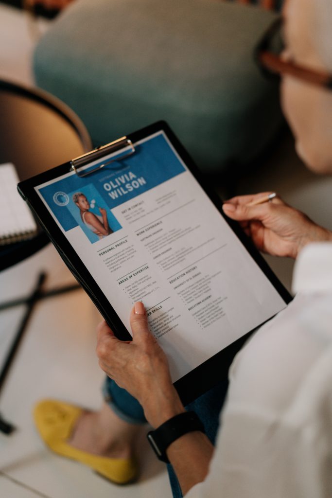 A woman holding a CV on on board.