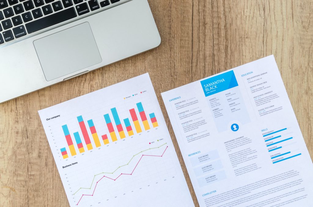 A laptop with  a CV and a chart. 