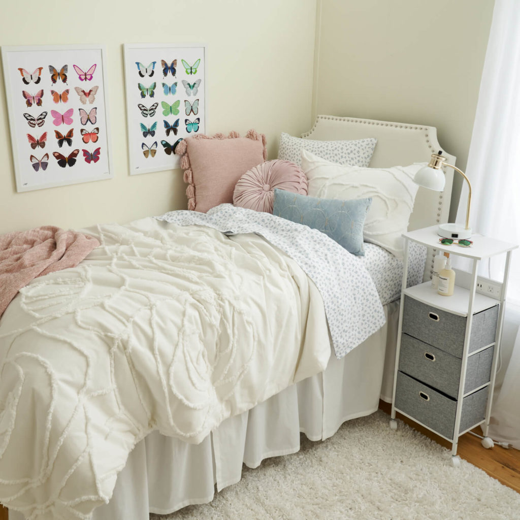 A bedroom with a bed, dresser, and pictures on the wall
