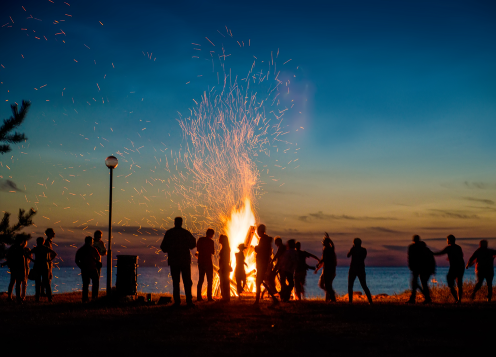 People standing around a bonfire - things to do over winter break