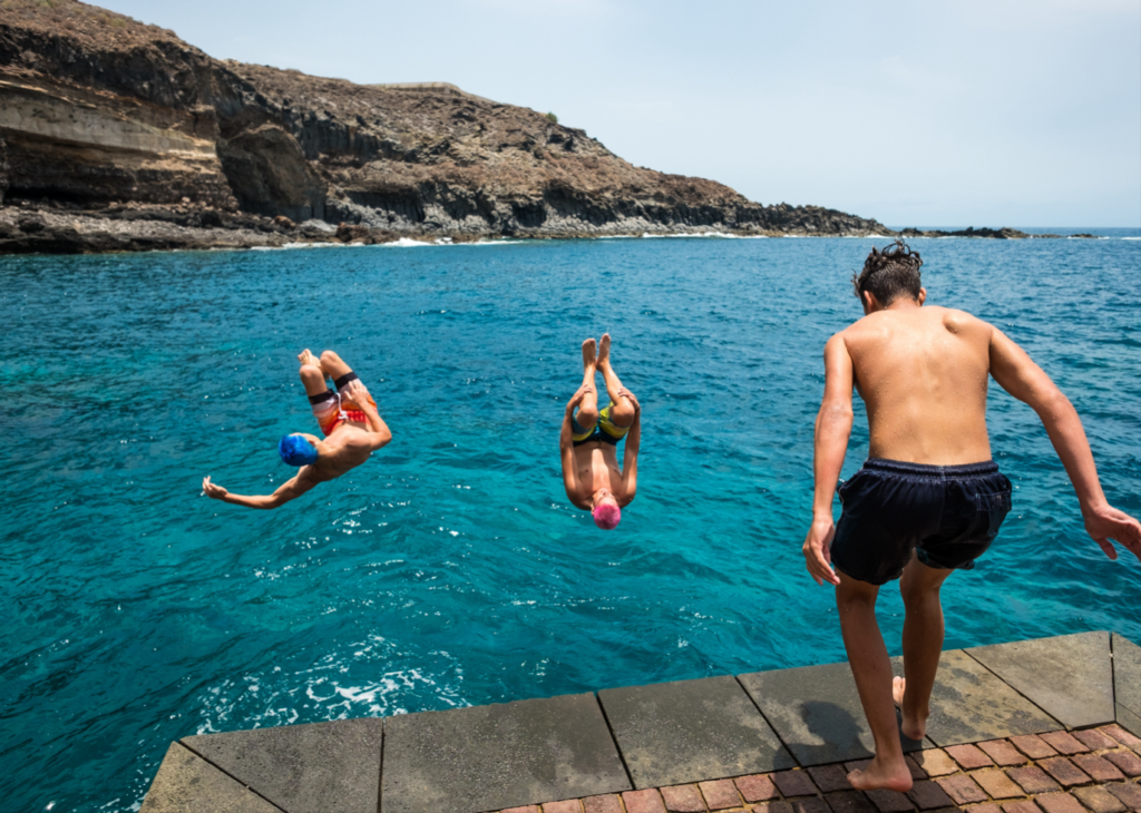 People doing backflips into the ocean - things to do over winter break