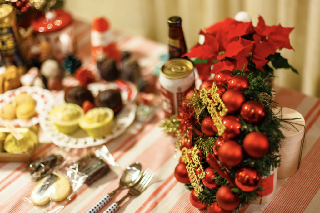Christmas wreath and poinsetta on a table surrounded by baked goods