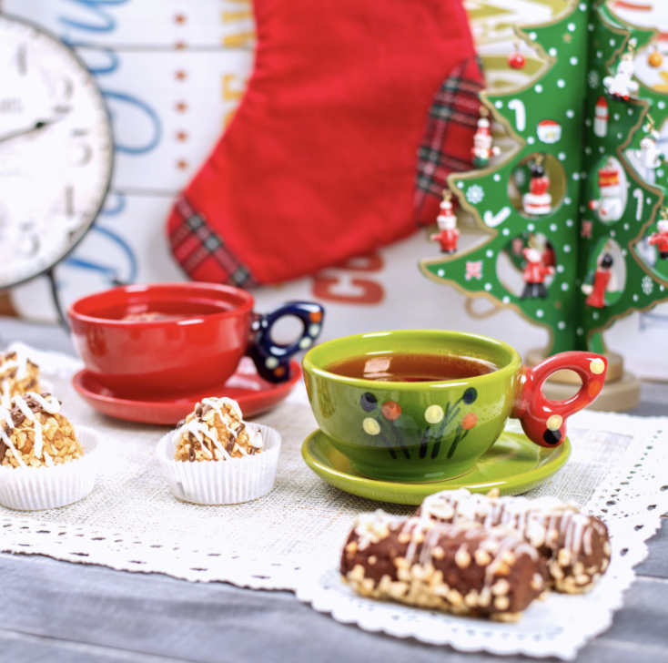 Mugs of tea and sweet treats on a table.