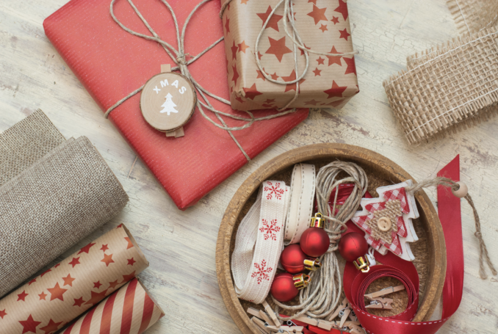 Flatlay photo of wrapped presents, ribbon, and ornaments.