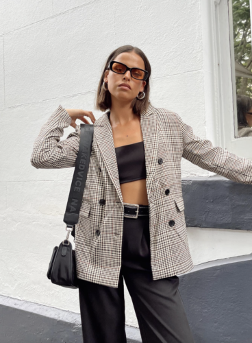 Black strapless bra top, black trousers, brown oversized plaid blazer