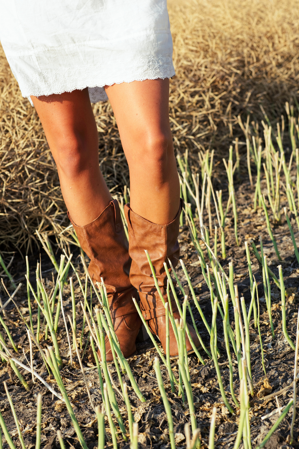 Woman feet wearing Cowboy Boots With A Dress