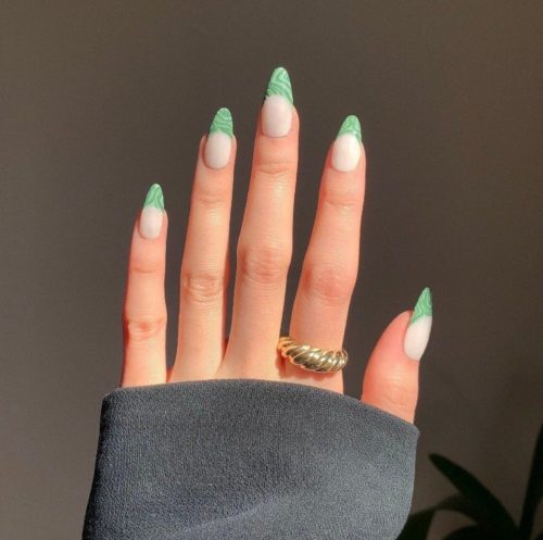 Photo of a white manicure with green swirl french tips
