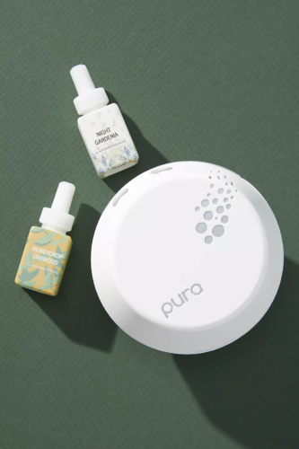 Photo of the Pura scent diffuser with two bottles of essential oils, Night Gardenia and Honeycrisp Oakwood