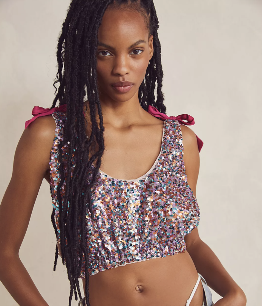 Model wearing a rainbow sequin crop top from Free People