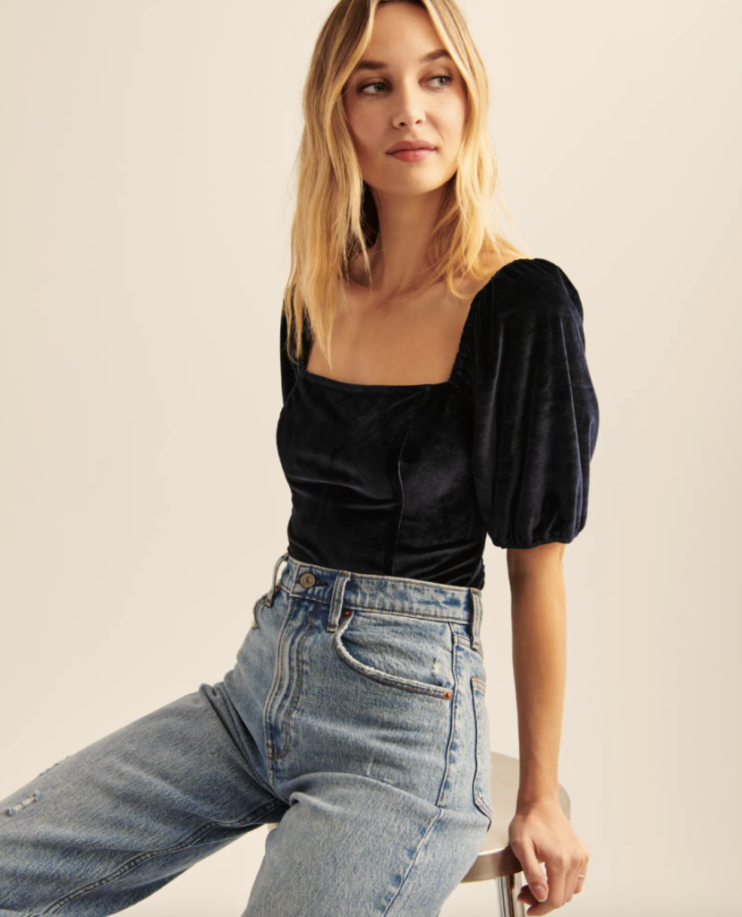 Casual NYE outfit with blue high-waisted jeans and velour puff sleeve top
