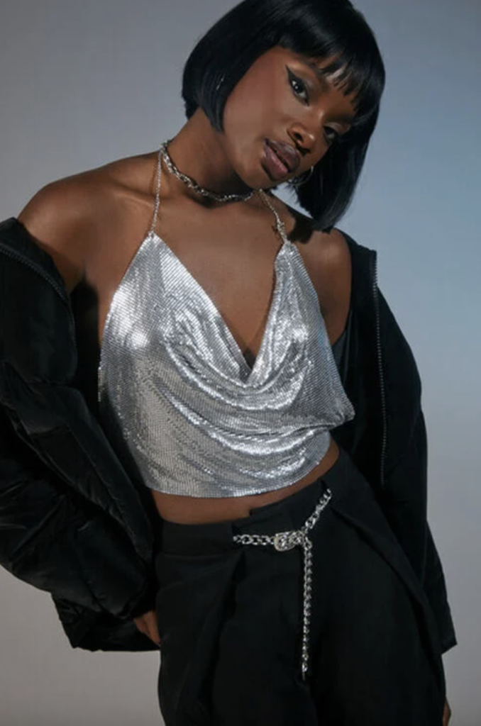 2000s sliver rhinestone cowl neck top styled with a black jacket, black jeans with a chain belt, and a silver choker