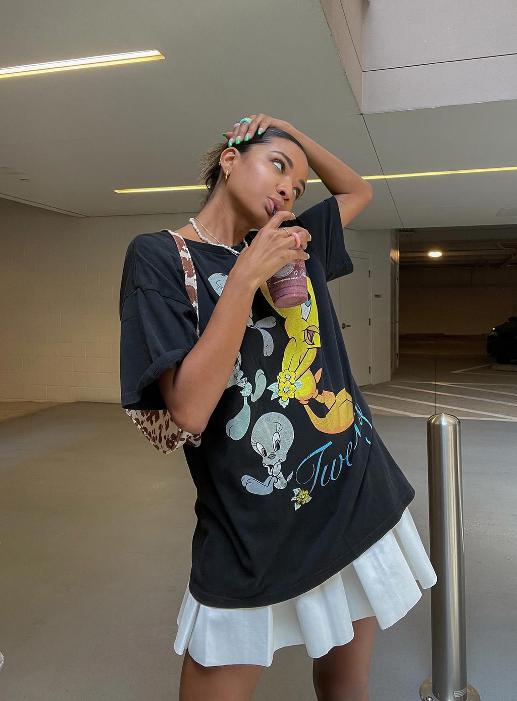 A girl posing with a Big Tee Over a Tennis Skirt.