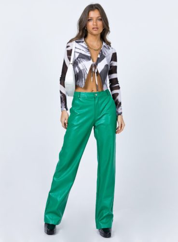 Bold outfit for the holidays: Green vinyl pants, long sleeved black and white printed crop top, white mini bag, black platform boots
